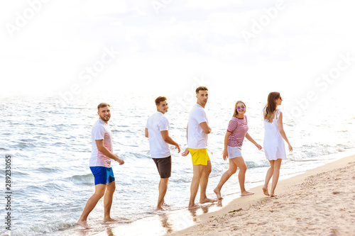 Happy friends on sea beach at resort