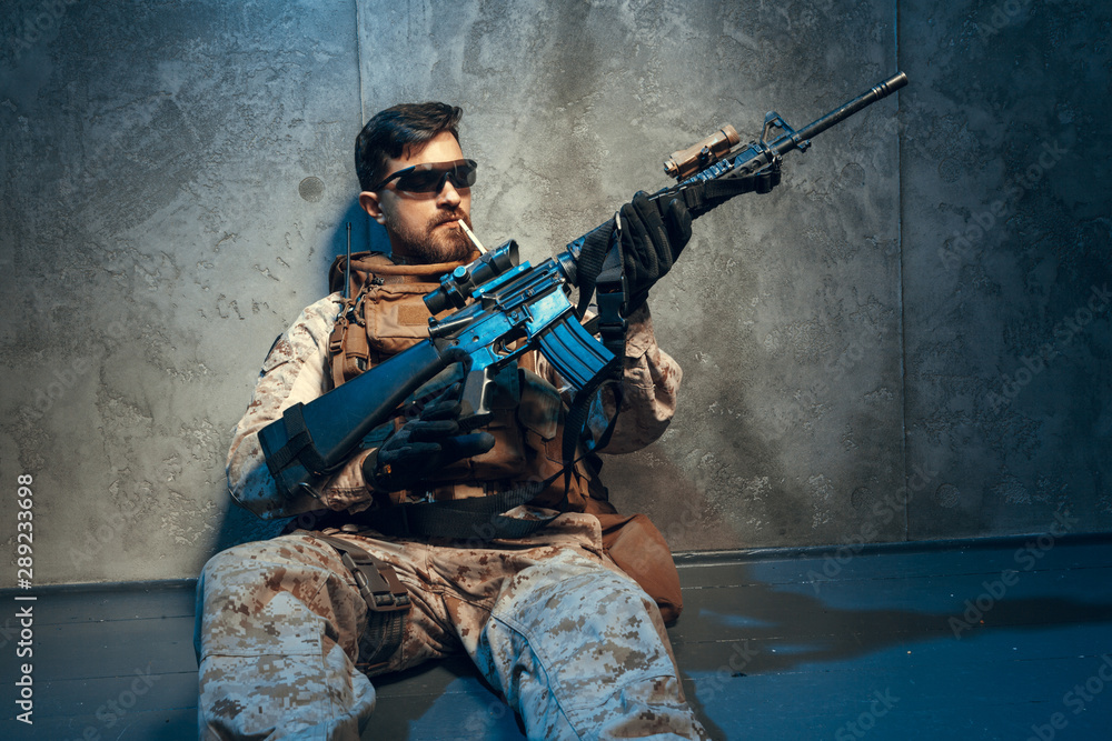Fototapeta premium American private military contractor holding rifle. Image on a dark background