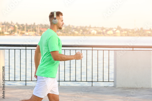 Handsome sporty man listeni...
