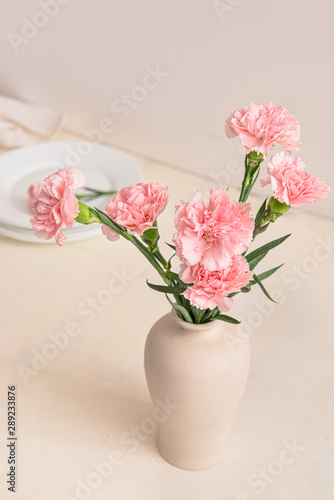 Beautiful carnation flowers in vase on table © Pixel-Shot