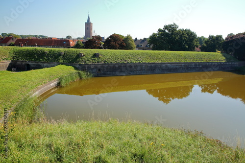 The fortifications and moats of the city of Naarden, Netherlands, with the Grote Kerk church in the background