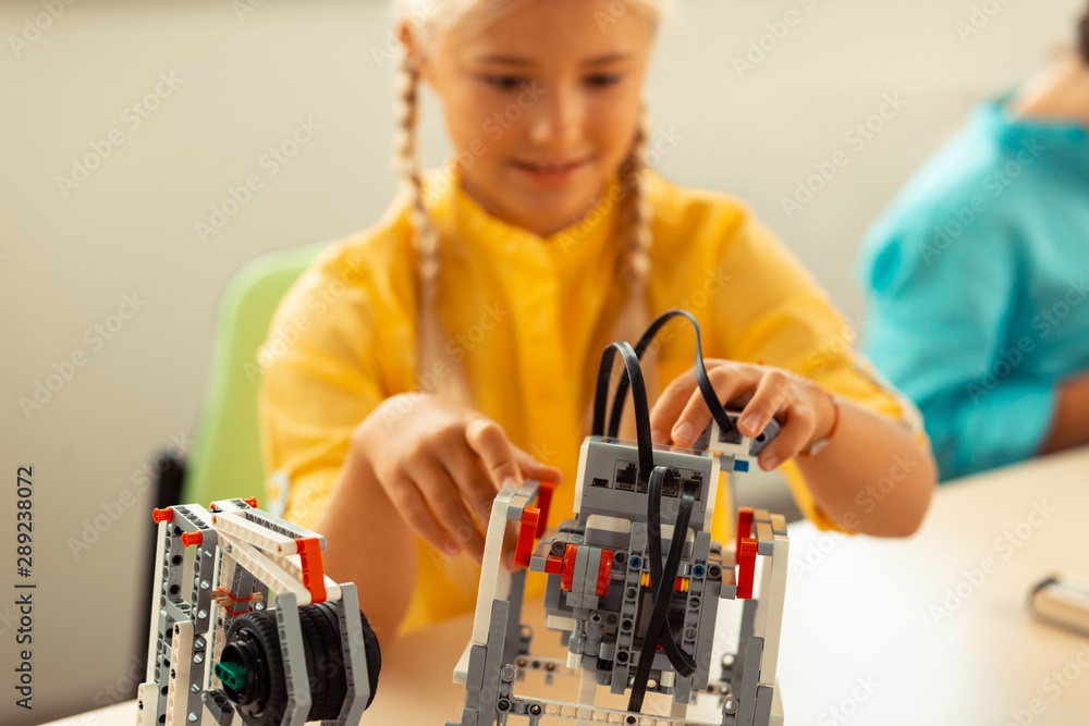 Girl building a robot at her science lesson.