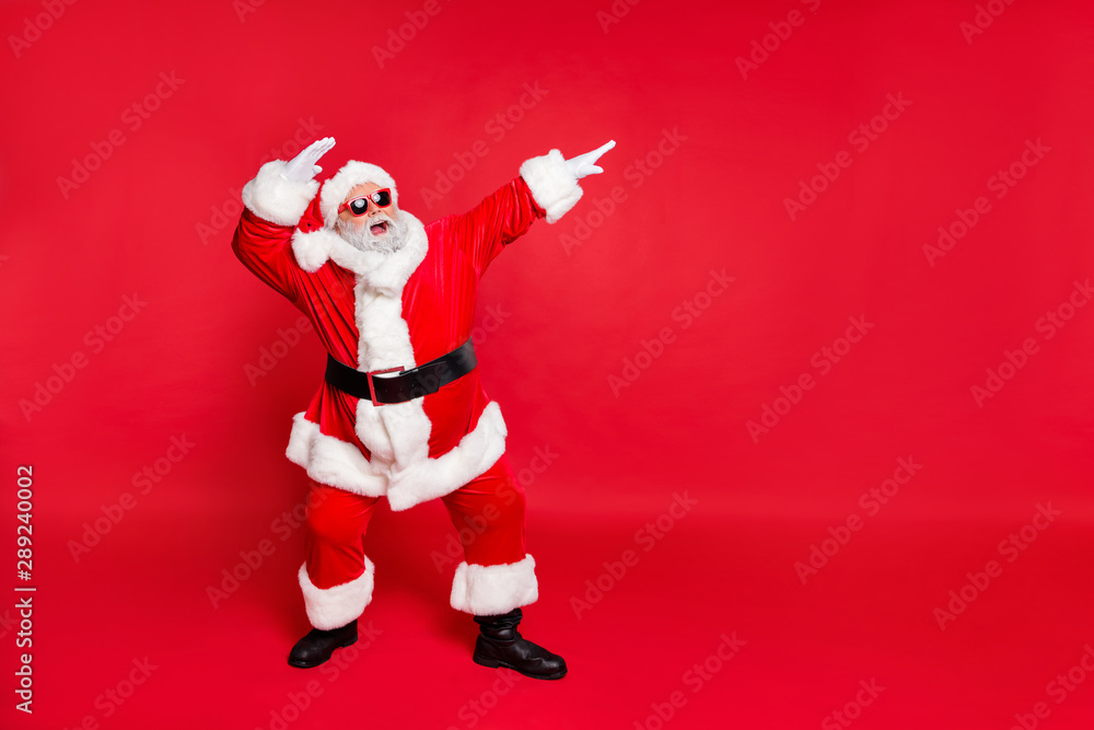 Full length body size view of his he nice attractive cheerful cheery careless bearded Santa having fun rejoicing fairy eve noel isolated over bright vivid shine red background Full length body size view of his he nice attractive cheerful cheery careless bearded Santa having fun rejoicing fairy eve noel isolated over bright vivid shine red background