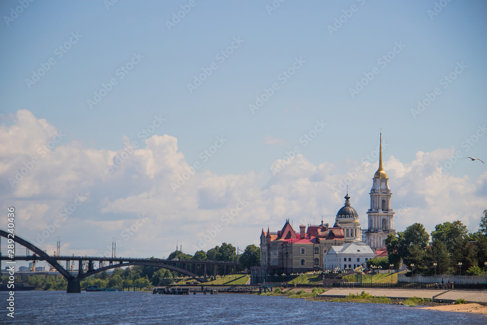 Obraz premium Rybinsk. View of the building of the grain exchange, the Holy Transfiguration Cathedral and the bridge over the Volga river. View from the river