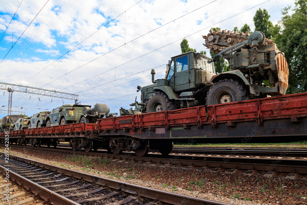 Cargo train carrying military vehicles on railway flat wagons Cargo train carrying military vehicles on railway flat wagons