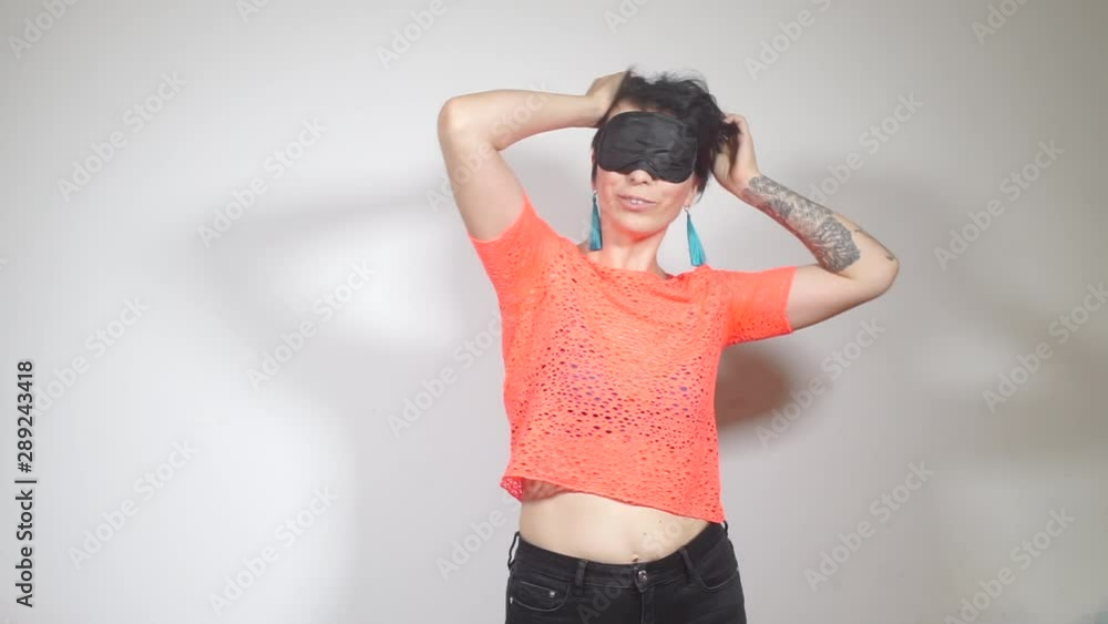 girl in front of a sleep mask, in an orange T-shirt with a tattoo on her arm girl in front of a sleep mask, in an orange T-shirt with a tattoo on her arm