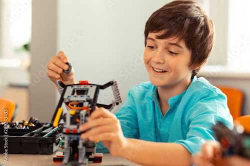 Boy finishing his work on the complicated robot.