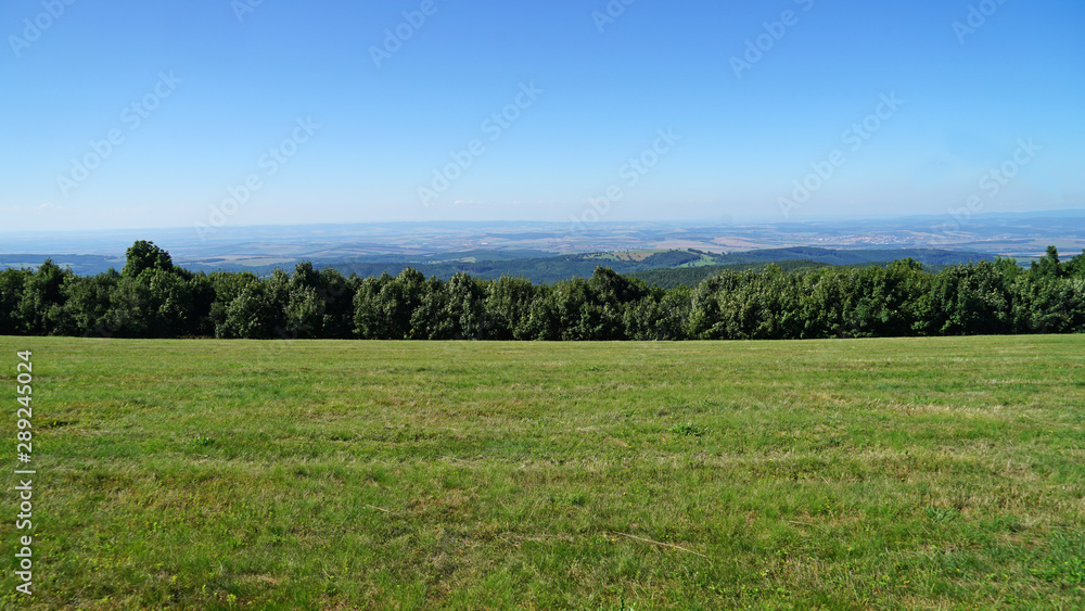 Grassland, forest and blue sky view from Velka Javorina, White Carpathians Mountains