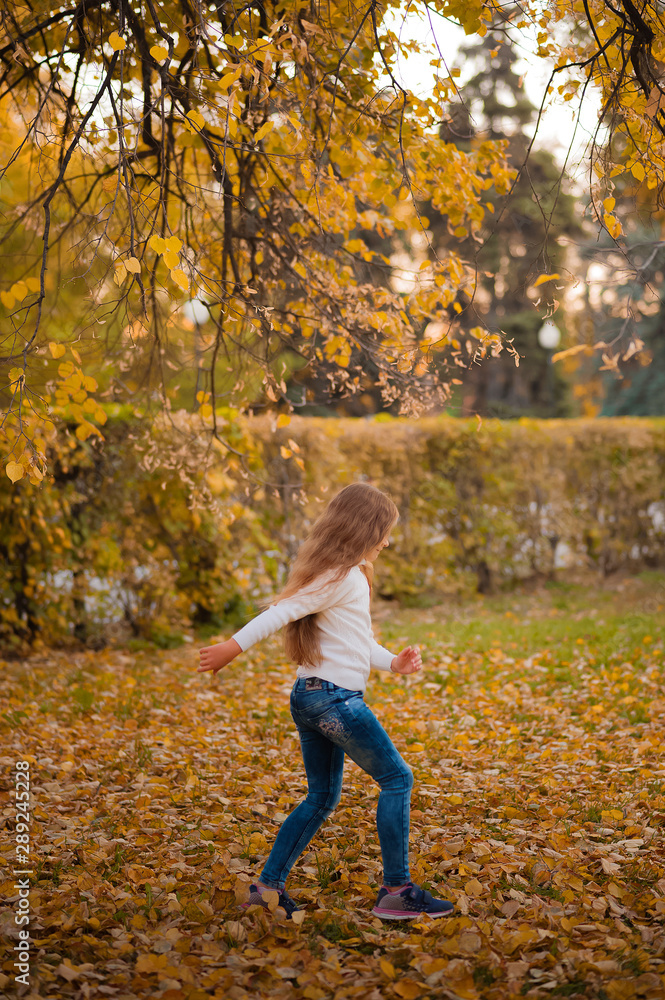 Little girl in autumn orange leaves. happy little child, baby girl laughing and playing in the autumn on the nature walk outdoors. Selective focus, copy space. Happy child with maple leaves in autumn Little girl in autumn orange leaves. happy little child, baby girl laughing and playing in the autumn on the nature walk outdoors. Selective focus, copy space. Happy child with maple leaves in autumn