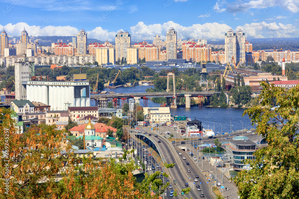 The landscape of the autumn city of Kyiv with a view of the Dnipro River, many bridges, the old Podilsky district and new houses on Obolon.