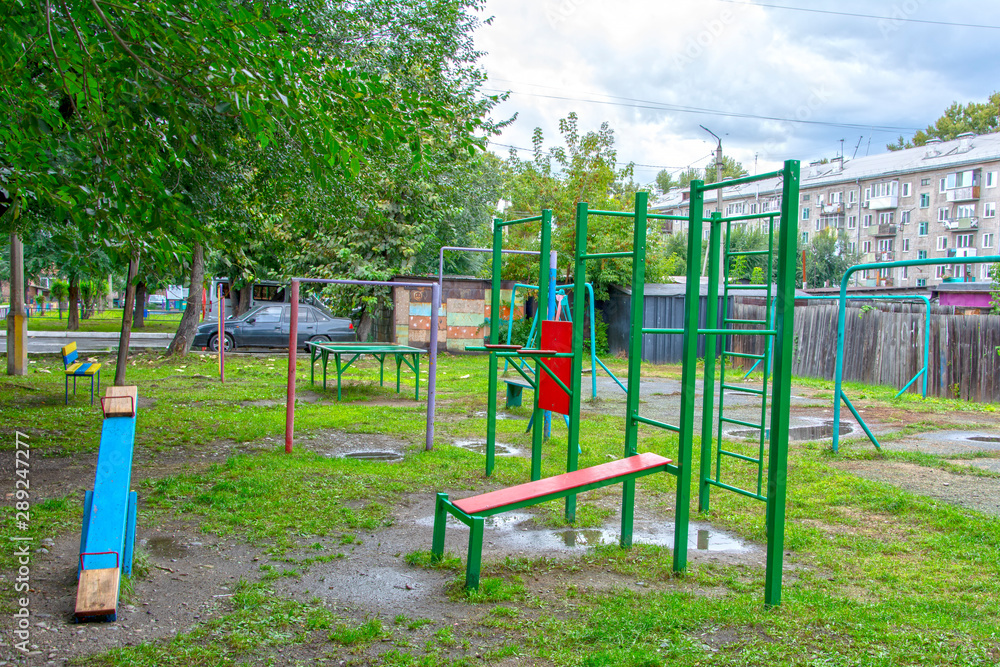 Children's playground after rain in the usual courtyard of an apartment building. provincial town. summer. Russia	