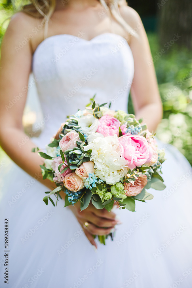 bride holds a wedding bouquet in her hands