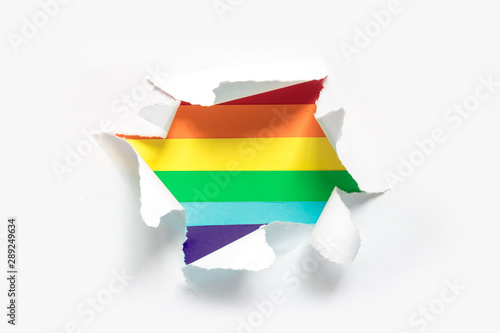 concept of gay pride, LGBT. LGBT gay pride heart sign, rainbow flag heart in a paper hole flat lay