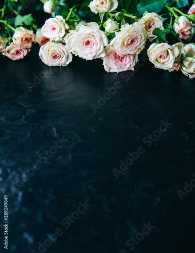 Beautiful flowers on black background. Roses bouquet. Perfect flat lay. Happy mother's holiday postcard. International women's day greeting. Stylish idea for advert or promotion.