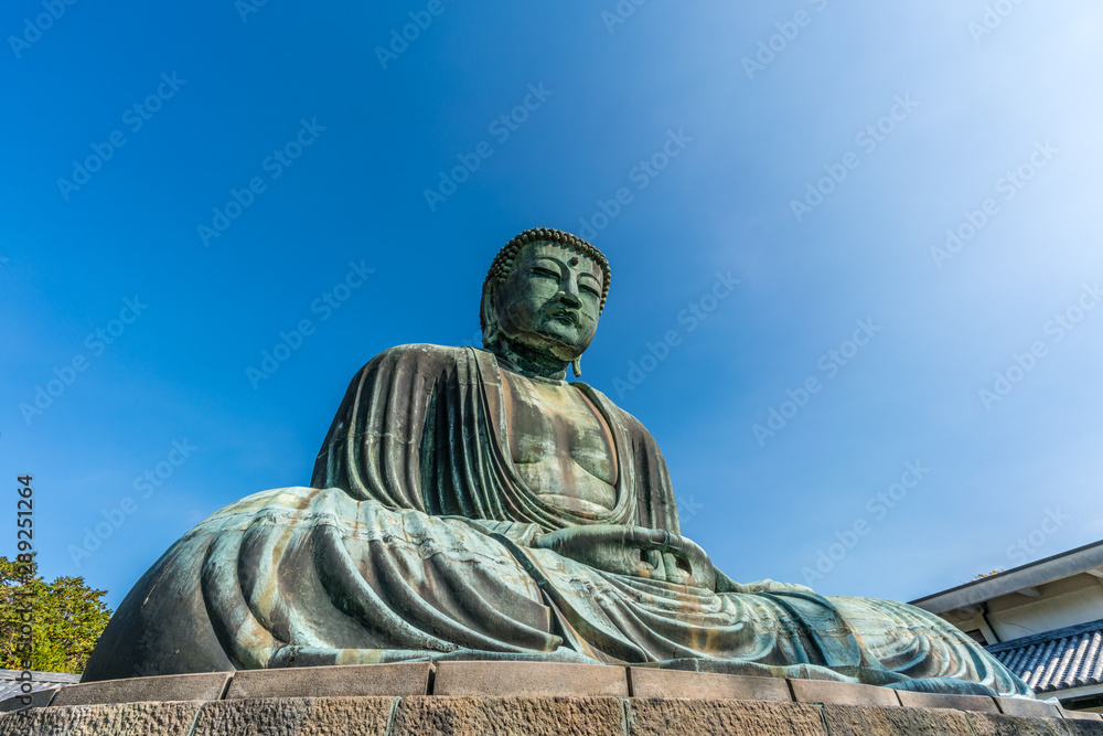 Monumental outdoor bronze statue The Great Buddha in Kamakura, Japan. Wide angle view with clear blue sky Monumental outdoor bronze statue The Great Buddha in Kamakura, Japan. Wide angle view with clear blue sky