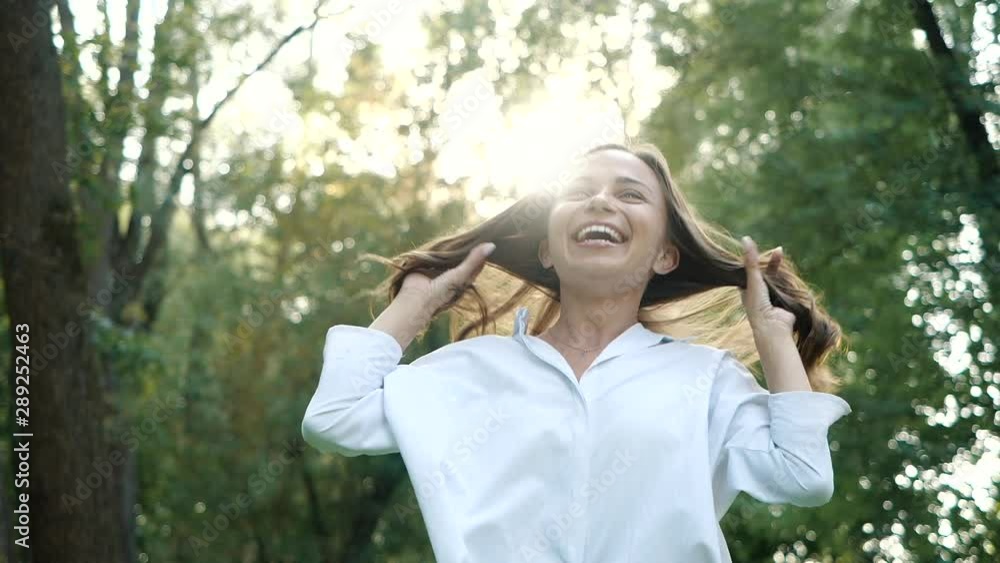 Close up portrait of Young brunette girl smiling. Happy awesome Woman with hair blowing in wind looking at camera and smiling. Slow motion. Close up portrait of Young brunette girl smiling. Happy awesome Woman with hair blowing in wind looking at camera and smiling. Slow motion.