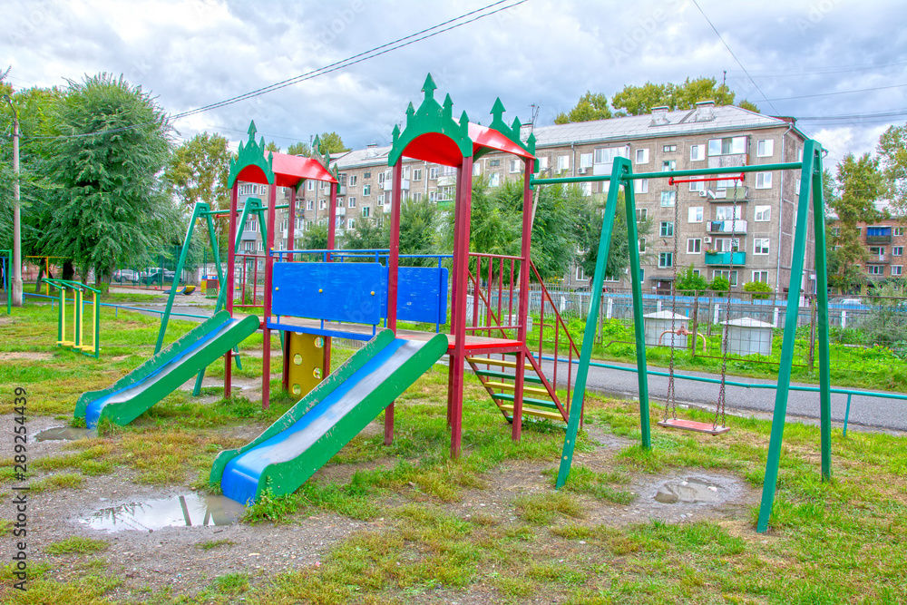 Children's playground after rain in the usual courtyard of an apartment building. provincial town. summer. Russia