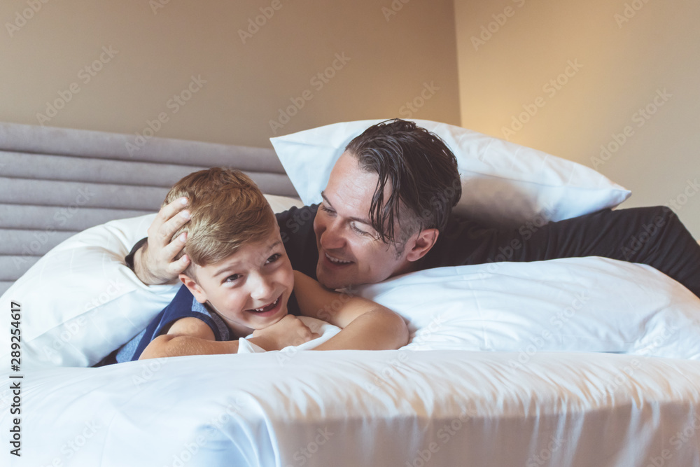 Loving father and son lying down on bed. Loving father and son lying down on bed.