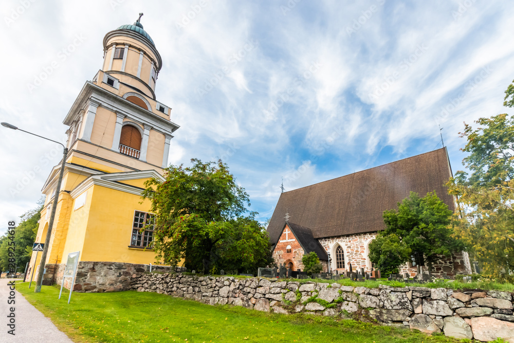 Hollola, Finland - 9 September 2019: Old medieval stone church of St. Mary and bell tower in Hollola, Finland