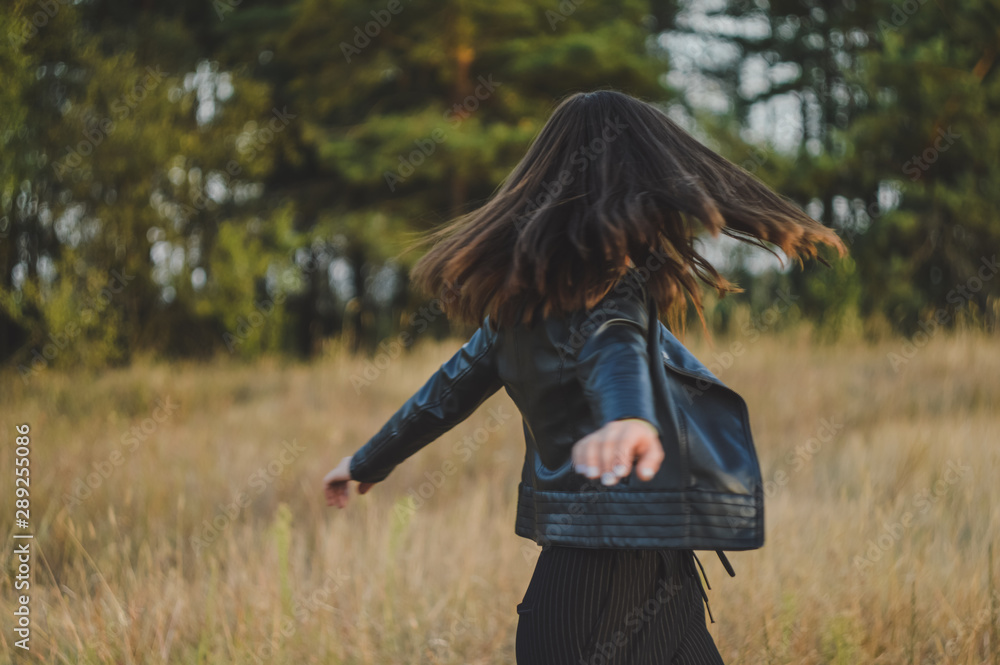 A young girl spinning on the background of the autumn landscape. Feeling of freedom and happiness. A young girl spinning on the background of the autumn landscape. Feeling of freedom and happiness.