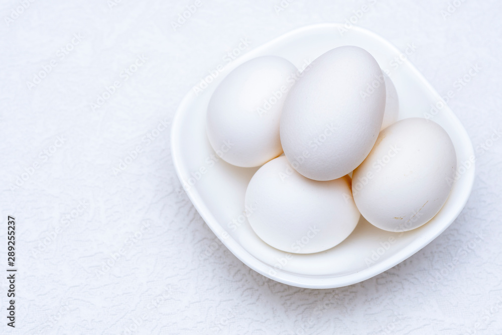 Close up shot of whole white eggs in a white bowl Close up shot of whole white eggs in a white bowl