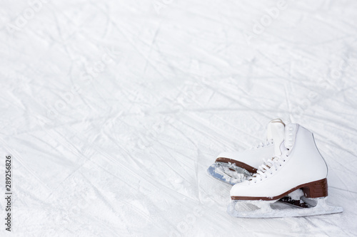close up of figure skates and copy space over ice with marks from skating