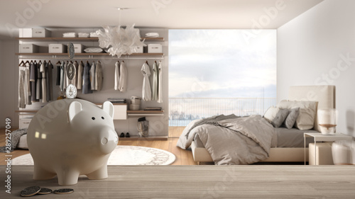 Fotografia Wooden table top or shelf with white piggy bank with coins, modern panoramic bed
