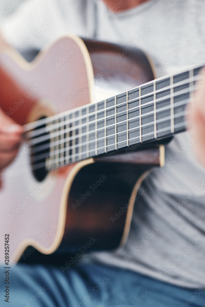 Fototapeta premium Man playing acoustic guitar in the living room.