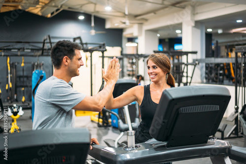 Adult couple running on a treadmill in a gym