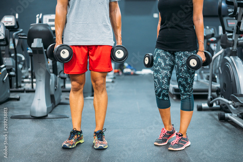 Middle-aged couple unrecognizable with the dumbbell, in the gym