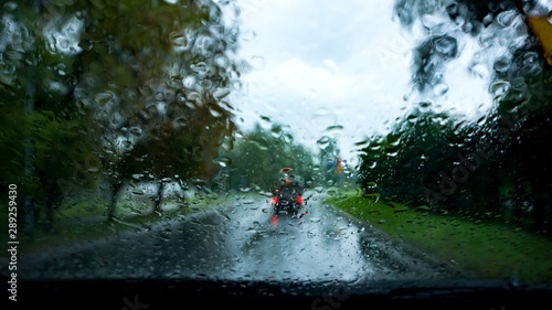 Rain droplets on car windshield . Look on the water drops on car windshield from inside the car at rain on the city street