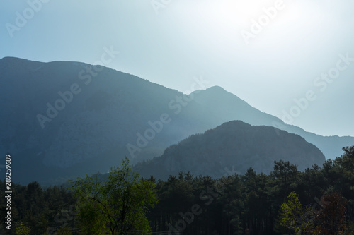 mountain chain in a mist and light of rising sun, beautiful outdoor travel background