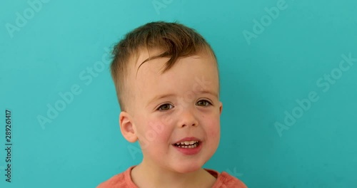 Portrait of a child who talks and answers questions instudio on blue background photo