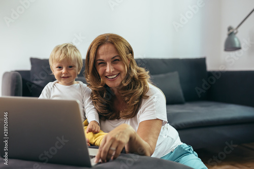 grandmother with her grandson using laptop computer at home