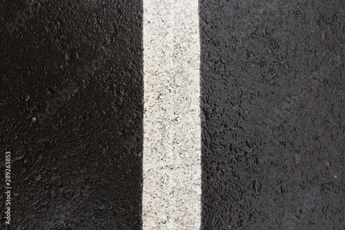 Wet asphalt background. Road marking. Black asphalt background. © Lena Philip