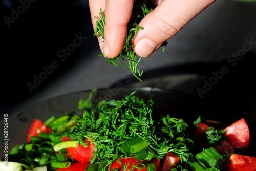 hands making salad close up