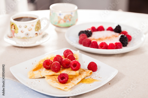breakfast of pancakes with fresh raspberries on table