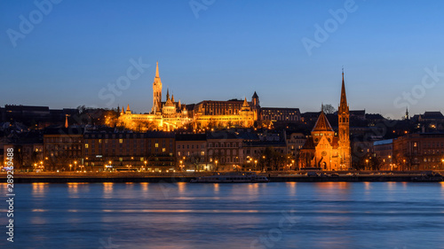 Panoramic view of Szilágyi Dezső Square Reformed Church and Matthias Church on the west bank of the river Danube captured at the blue hour. © Tommy Larey