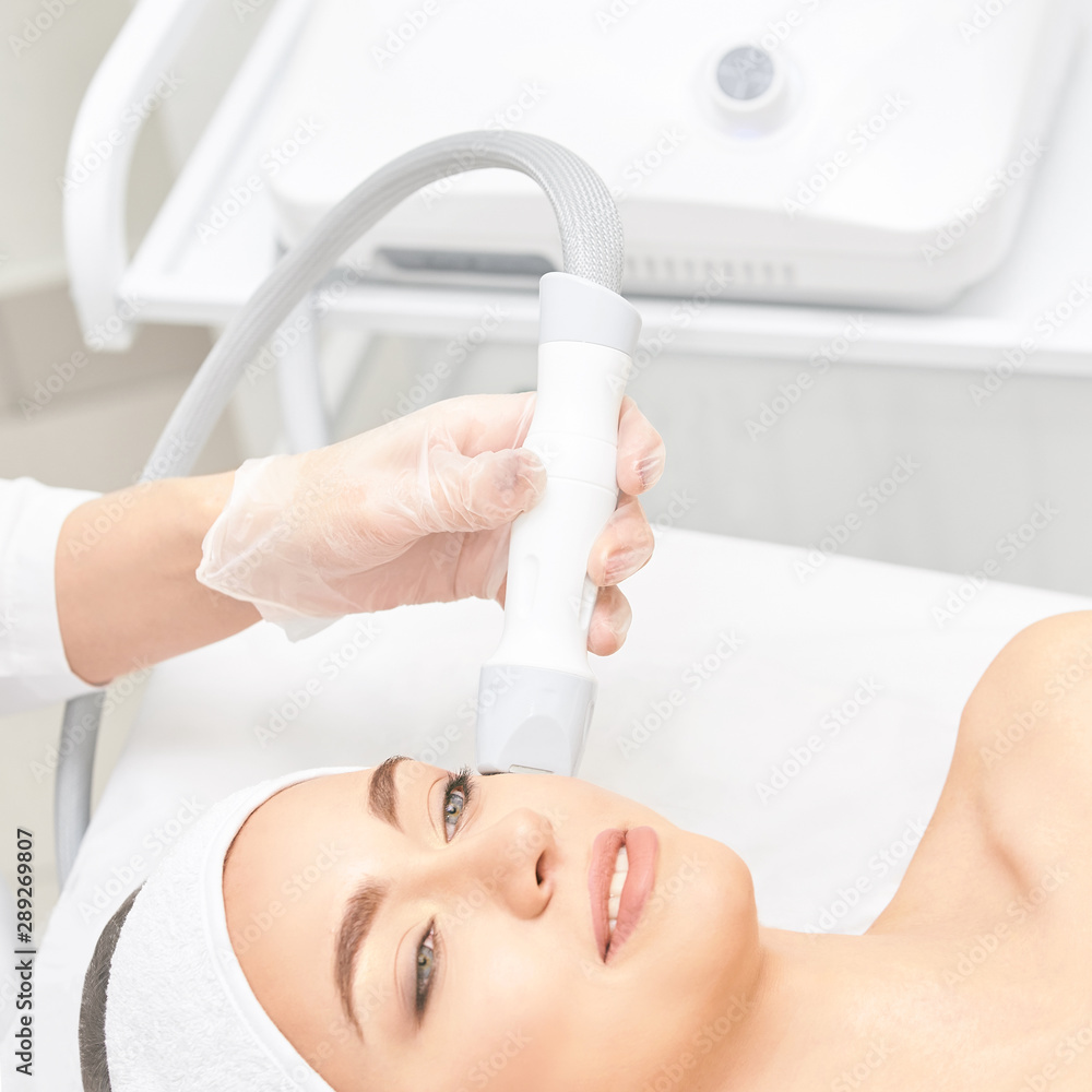 Naklejka premium Vacuum face cosmetology equipment. Facial salon cleaning. Youn girl professional skin care. Beauty woman and health device