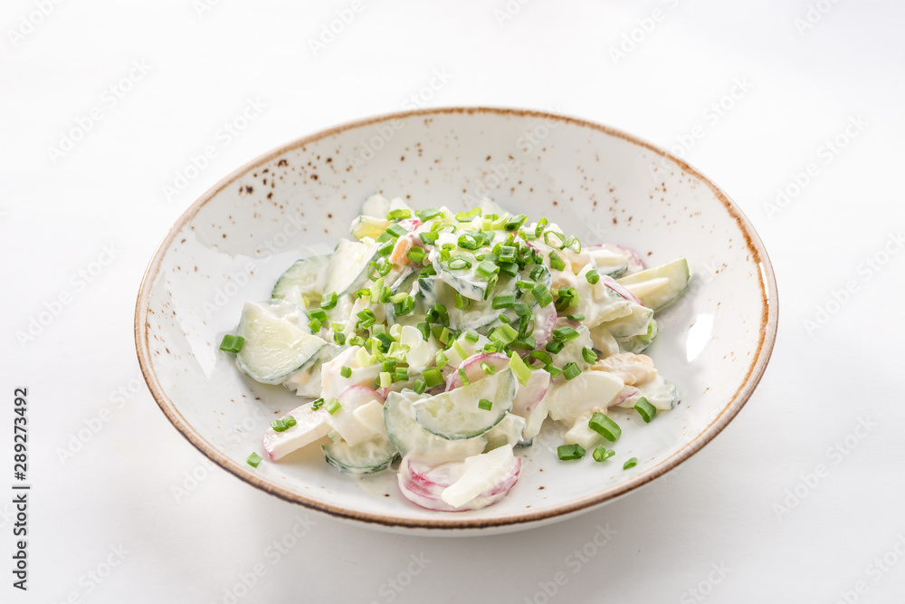 Salad fresh cucumbers and radish with sour cream and onion isolated on white background Salad fresh cucumbers and radish with sour cream and onion isolated on white background