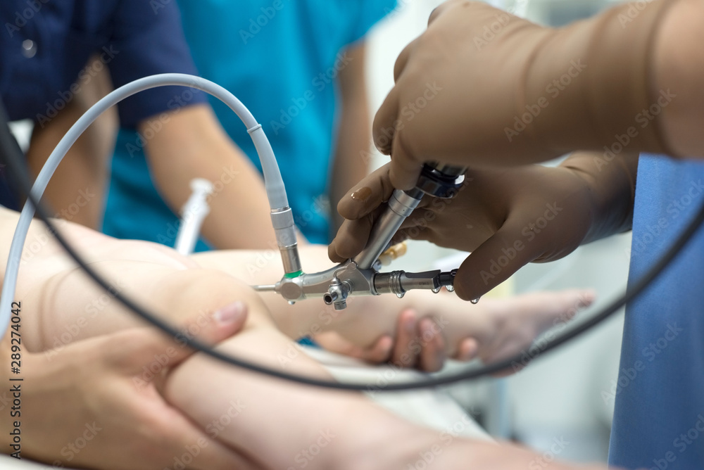 A team of urologist doctors performing a cystoscopy using a cystoscope. In a sterile operating room. close-up A team of urologist doctors performing a cystoscopy using a cystoscope. In a sterile operating room. close-up