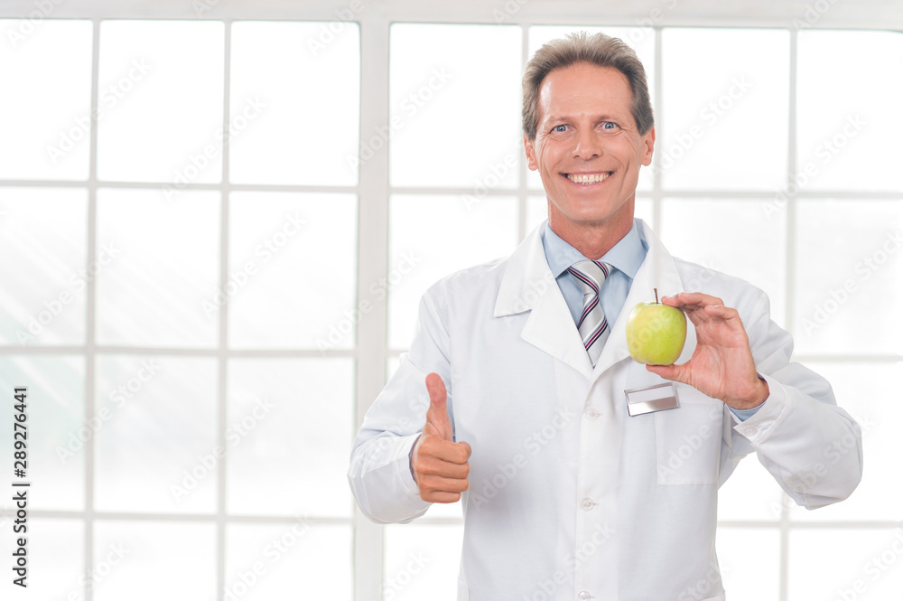 Senior doctor at his office in hospital working thumb up healthy food Senior doctor at his office in hospital working thumb up healthy food