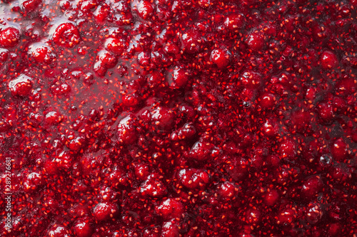 beautiful glare texture of raspberry jam closeup, food background photo