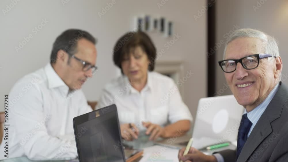 Business team at work with graphs, digital tablet and laptop in a modern office. Teamwork with mature businessman manager leader and CEO. Business leader. Business team at work with graphs, digital tablet and laptop in a modern office. Teamwork with mature businessman manager leader and CEO. Business leader.