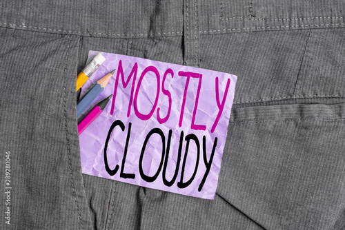 Conceptual hand writing showing Mostly Cloudy. Concept meaning Shadowy Vaporous Foggy Fluffy Nebulous Clouds Skyscape Writing equipment and purple note paper inside pocket of trousers
