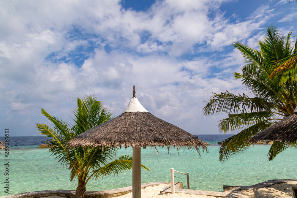 ein schöner Strand mit Sonnenschirm und Palmen ein schöner Strand mit Sonnenschirm und Palmen