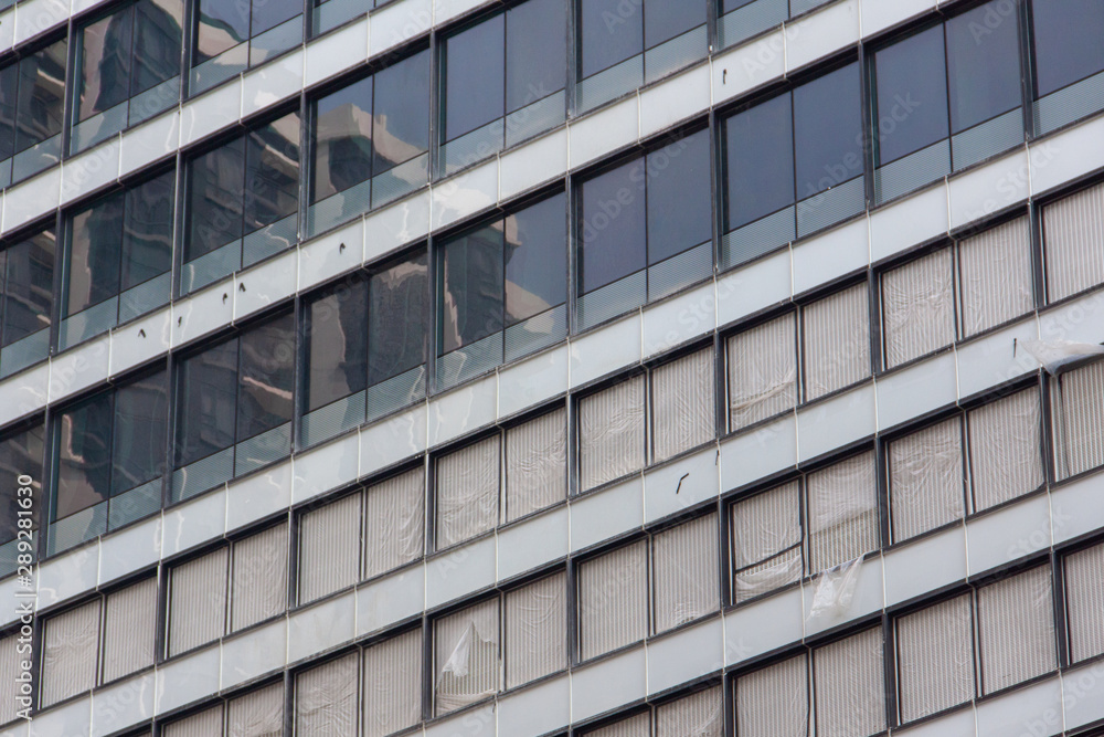 Glass windows and concrete walls in the daytime. Arcitectural fragment of modern building in Bangkok, Thailand. Glass windows and concrete walls in the daytime. Arcitectural fragment of modern building in Bangkok, Thailand.