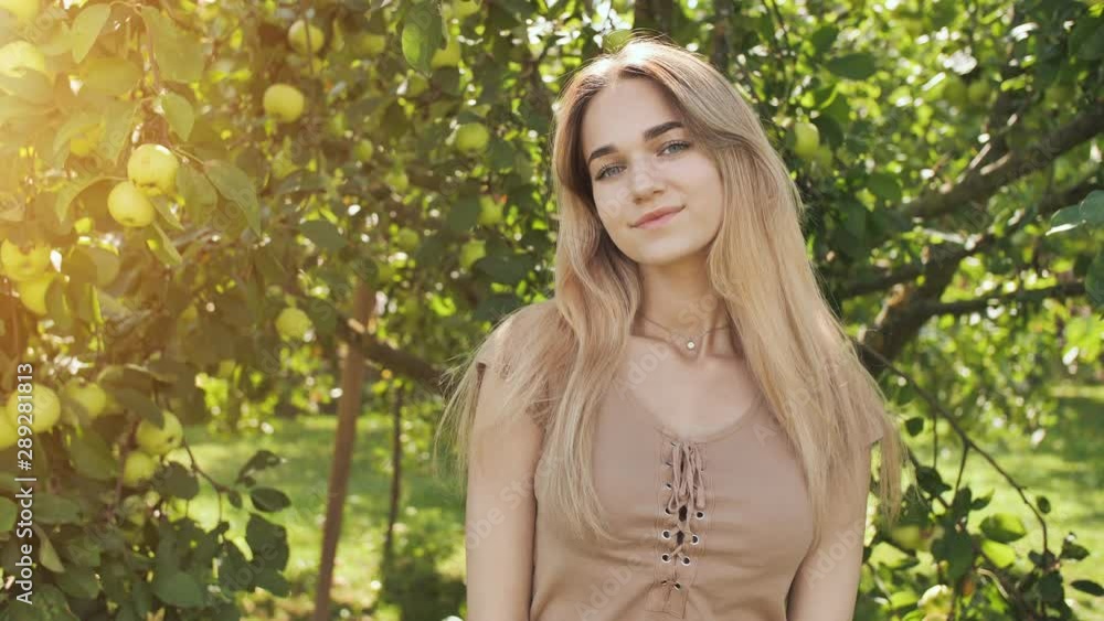 Beautiful seventeen year old girl blonde posing in the branches of an apple tree Beautiful seventeen year old girl blonde posing in the branches of an apple tree