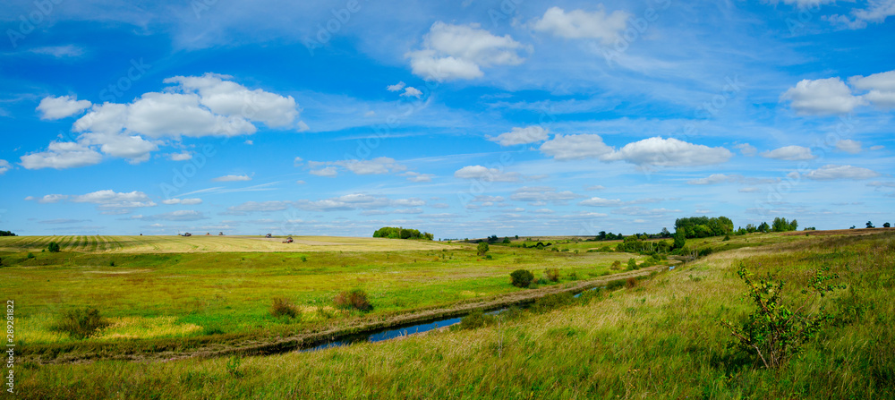 Beautiful panoramic landscape with river and golden fields