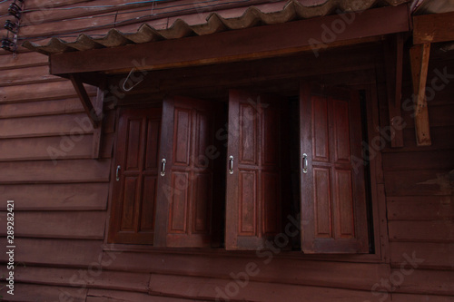 Traditional Asian house made of dark wood, with open windows.